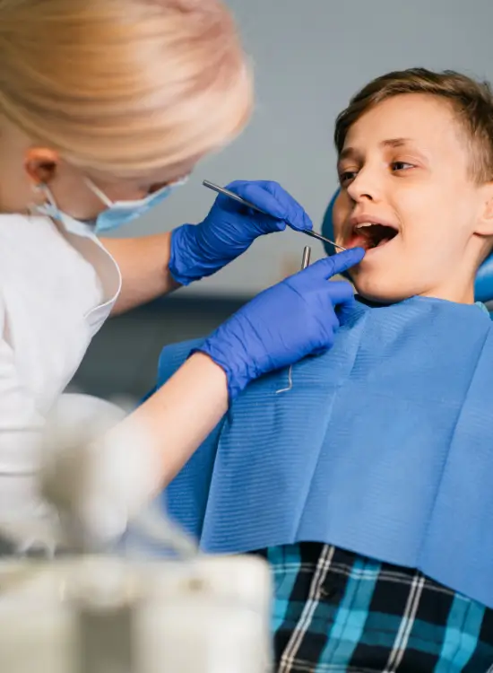 Young boy having his teeth examined by his dentist