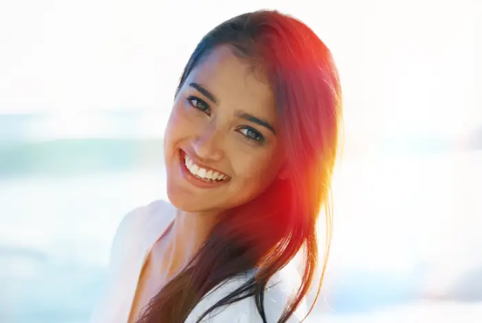 Young woman with red hair smiling outdoors