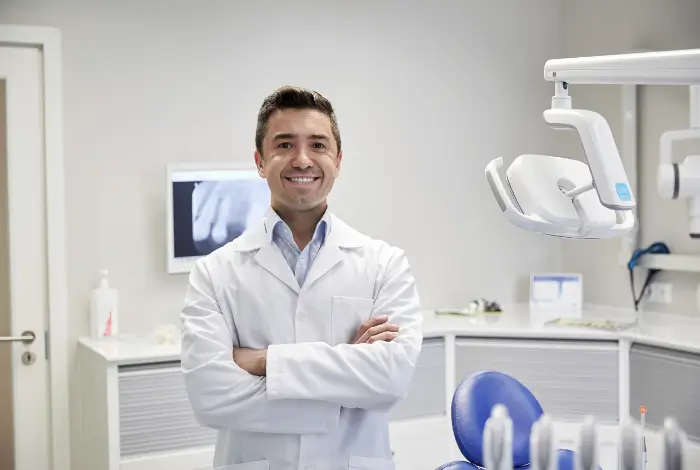 Dentist smiling with his arms crossed