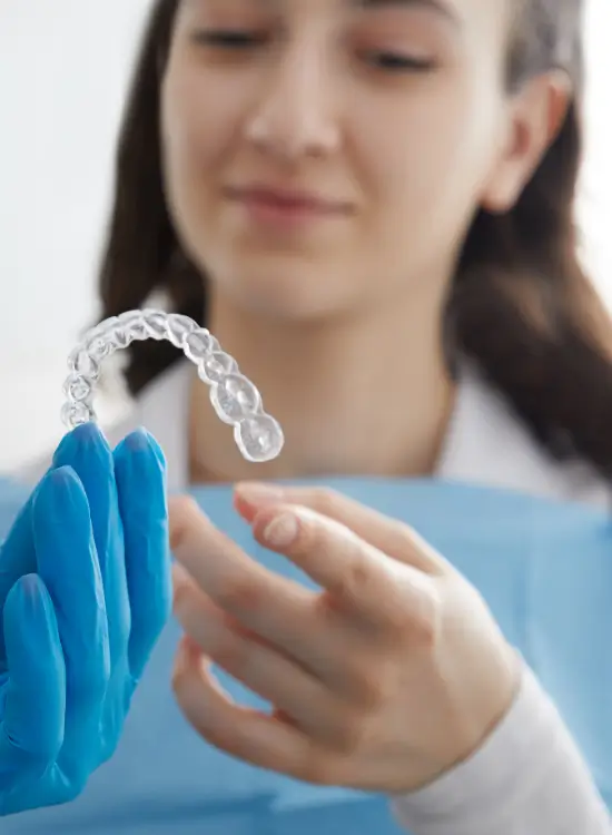 Dentist handing a clear aligner to a patient